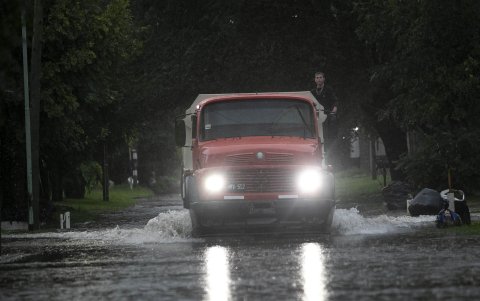 Un vehículo transita este miércoles por una calle inundada debido a un temporal de lluvia durante la noche, en La Plata, provincia de Buenos Aires (Argentina).