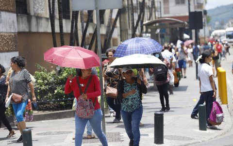 En los últimos días, los ciudadanos se cubren del sol con paraguas.