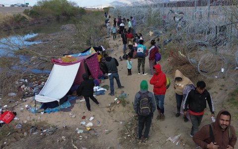Migrantes permanecen junto al alambrado que divide a México con Estados Unidos,  en Ciudad Juárez (México), esperando el momento para cruzar el cerco.