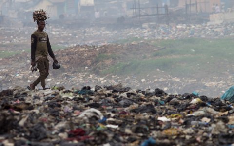 Un hombre transporta cables sobre su cabeza en el vertedero de Agbogbloshie, un barrio de Accra, capital de Ghana,