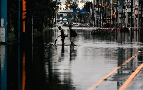 Dos hombres caminan por una calle inundada