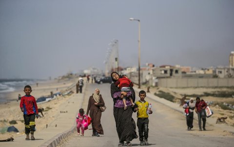 Palestinos, incluidos mujeres y niños, que cruzan del norte al sur de Gaza caminan por la carretera Al Rashid, Franja de Gaza, el 21 de marzo de 2024