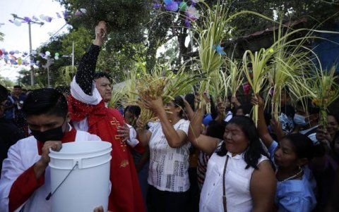 Un sacerdote bendice a los feligreses durante la celebración del Domingo de Ramos.