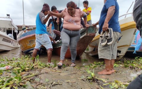 Malestar. Los ciudadanos reclaman que deben pedir ayuda a varias personas para que uno baje. Hay quienes se quitan los zapatos para tener mejor estabilidad en el fango.