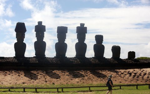 Una persona camina frente al Ahu Nau Nau, una plataforma con siete moais, el 2 de abril de 2024 en la Isla de Pascua