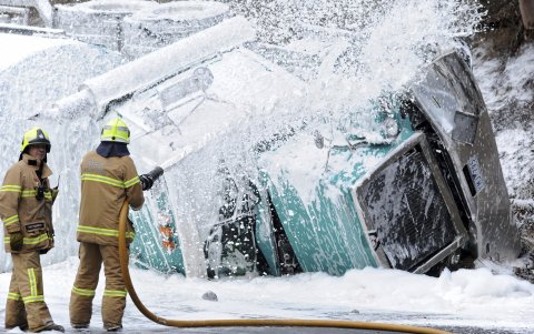 bomberos rocían con espuma un camión cisterna cargado con gasolina tras sufrir un accidente en la Autopista Calder en Keilor East, en el noroeste de Melbourne, Australia.