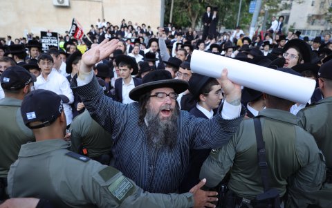 La policía intenta detener la protesta de los judíos ultraortodoxos que se manifiestan en contra el reclutamiento militar frente a la oficina de reclutamiento militar en Jerusalén.