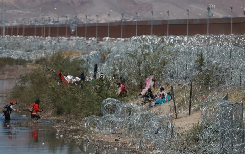 Migrantes llegan a una orilla del Río Bravo sembrada con alambre de púas, en Cudad Juárez, Chihuahua (México).