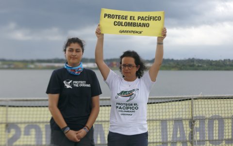 Tatiana Céspedes sostiene un cartel junto a otra tripulante a bordo del buque Artic Sunrise,