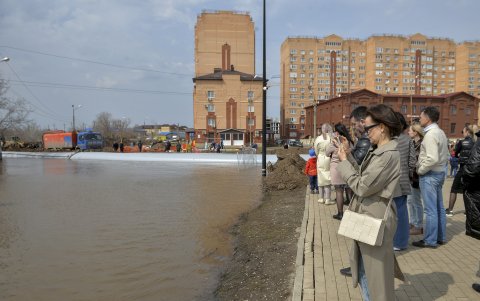 Residentes locales examinan el terraplén impermeable en la zona residencial inundada en Orenburg, región de Orenburg, Rusia, el 12 de abril de 2024.
