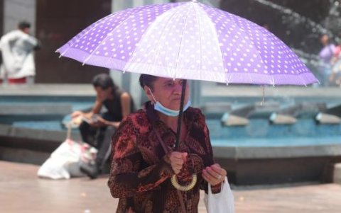 Una ciudadana optó por usar una sombrilla para evitar recibir los rayos del sol.