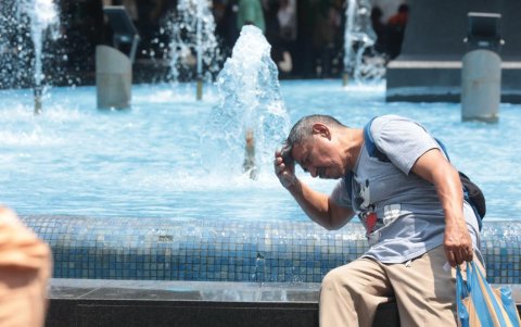 Un ciudadano se moja en una pileta en el centro de Guayaquil.