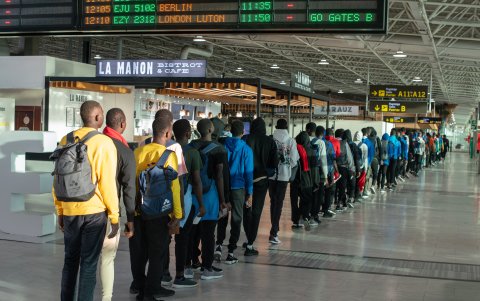Un grupo de inmigrantes africanos llegados en pateras y cayucos a Canarias espera en el aeropuerto de Fuerteventura a embarcar en un vuelo a la península.