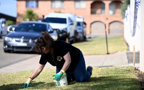 Un feligrés retira vidrios rotos del césped en la Iglesia de Cristo el Buen Pastor en el suburbio de Wakeley, en Sydney, Australia, el 16 de abril de 2024.