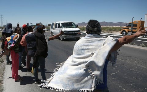 Un grupo de migrantes piden un aventón mientras caminan a un costado de la carretera rumbo a la frontera con Estados Unidos.