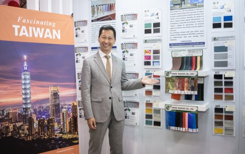 Augusto Liao, representante gubernamental de la Oficina Comercial de Taipéi en Ecuador, junto a las muestras y catálogos expuestos en su stand.