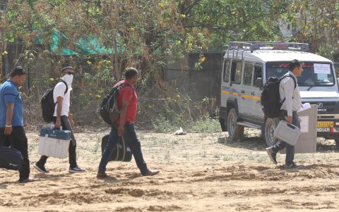 Los funcionarios electorales caminan con las máquinas de votación electrónica, justo antes de su viaje a los colegios electorales.