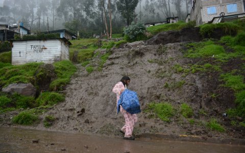 En medio de la lluvia Viviana sacó sus pertenencias de la casa que resultó afectada por el lodo.
