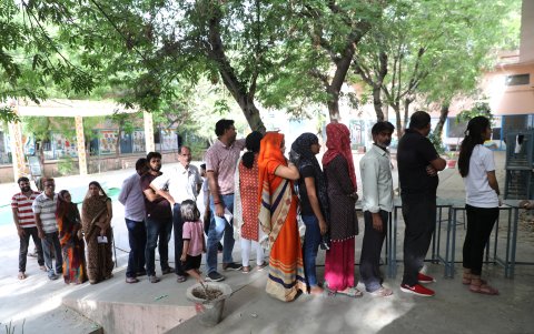 La gente hace cola en un colegio electoral para emitir su voto en la primera fase de las elecciones generales en la aldea de Kotputli en Rajasthan, India, el 19 de abril de 2024.
