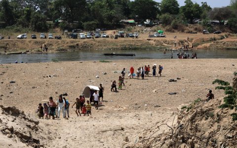 BIrmanos cruzan el río Moei en la frontera entre Birmania y Tailandia para huir de los enfrentamientos entre las fuerzas pro y anti junta militar.