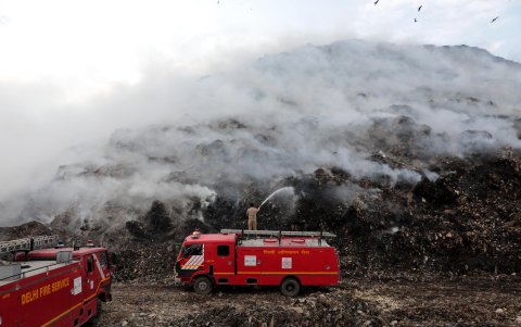Varios bomberos trabajan en apagar el incendio declarado en un basurero en Ghazipur, Nueva Delhi (India) este lunes.