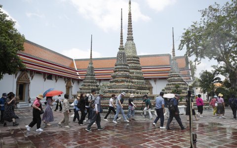 Turistas se protegen este viernes de las altas temperaturas en el templo Pho (o del Buda Reclinado) en Bangkok ante una ola de calor.