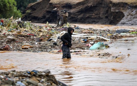 Varias personas recorren una zona inundada tras el colapso de una presa.