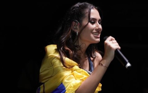 Fátima durante el concierto de Danna en Guayaquil, abrigada con la bandera de Ecuador.