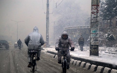 Varias personas se movilizan por una avenida de la capital del país del mundo musulmán, bajo un día de fuertes precipitaciones.