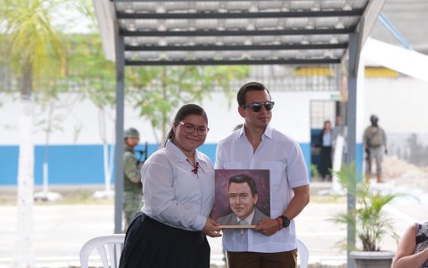 La estudiante Gisel Falconez entrega un retrato al presidente Daniel Noboa en nombre de su unidad educativa, Los Vergeles