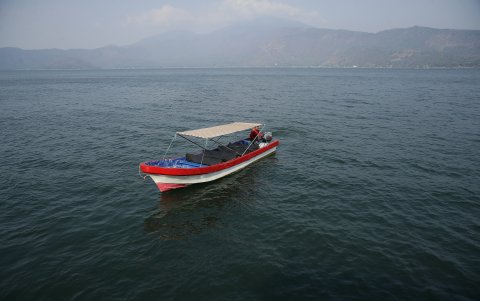 Un lanchero que ofrece viajes turísticos recorriendo el Lago de Coatepeque, el 26 de abril de 2024 en El Congo