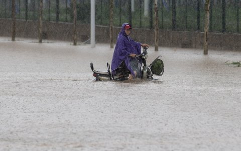 Un hombre que pasea en su motocicleta durante una calle inundada después de una fuerte tormenta en Wuhan, China.