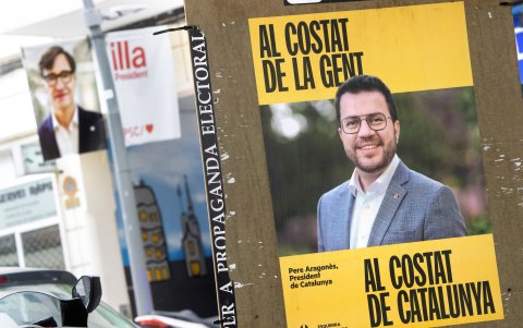 Dos carteles de propaganda política para las elecciones catalanas de este domingo: en primer término, la imagen del candidato independentista Pere Aragonés (ERC); detrás, el socialista Salvador Illa.