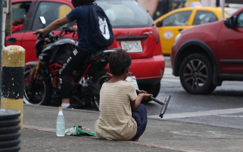 Un menor en edad escolar se dedica a limpiar parabrisas en una calle del centro de Guayaquil.