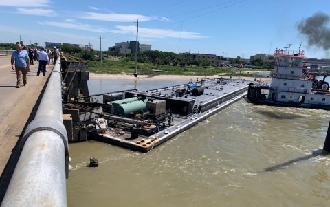 Las personas caminan junto al puente que chocó una barcaza en Pelican Island, este miércoles en Galveston (Estados Unidos).