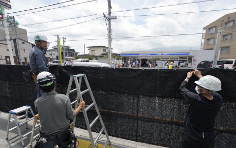 Los trabajadores instalan una red de sombra negra en el lado opuesto de la tienda Lawson Kawaguchiko Ekimae en Fujikawaguchiko, al norte del Monte Fuji, Japón, el 21 de mayo de 2024.