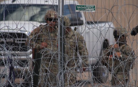 Personal de la Guardia Nacional estadounidense permanecen junto a una cerca de navajas y púas en el muro fronterizo entre México y EEUU,