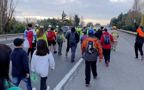 Personas acompañan a Camila Gómez (c-i), durante su caminata para recaudar dinero para la enfermedad de su hijo Tomás