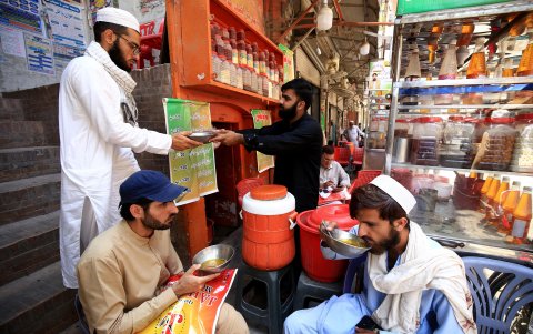 A los clientes se les sirve una bebida refrescante que consiste en jugo mezclado con hielo y semillas en un puesto al borde de la carretera en un día caluroso en Peshawar, 23 de mayo de 2024.