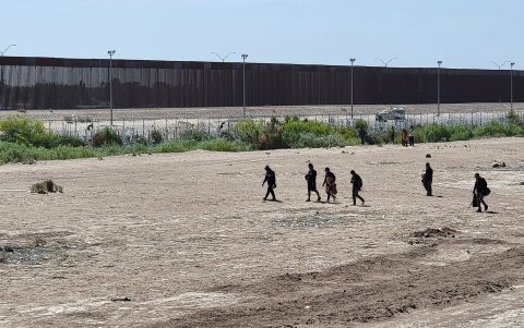 Migrantes caminan por una orilla de la línea divisoria entre México y EE.UU. este jueves 23 de mayo de 2024, en Ciudad Juárez, en el estado de Chihuahua (México).