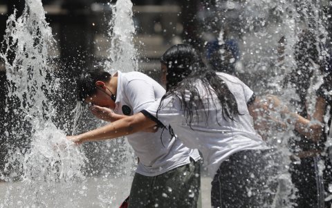 Personas se refrescan en la fuente en un parque este 23 de mayo, en la Ciudad de México