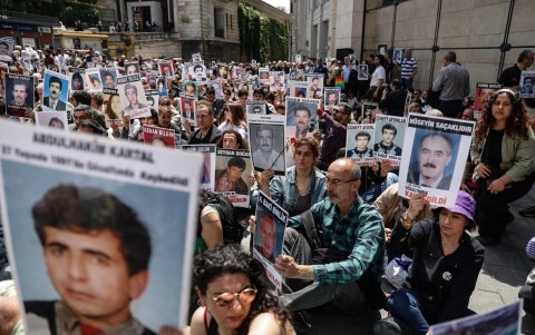 Los participantes tienen fotografías de personas y familiares desaparecidos durante la reunión semanal número 1.000.