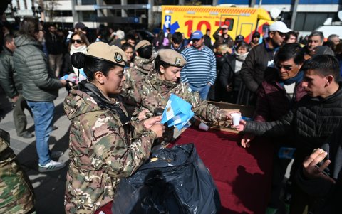 Integrantes de las Fuerzas Armadas Argentinas comparten bebidas con personas en el Día de la Patria, en la ciudad de Córdoba (Argentina).