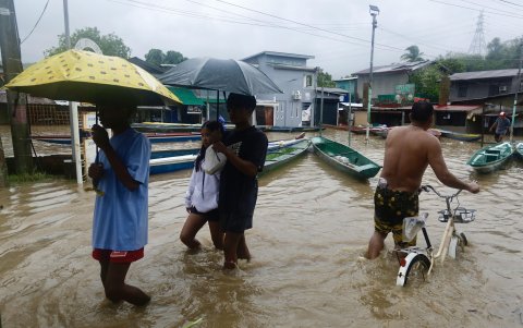 Aldeanos caminan por una zona inundada en la ciudad de Pagsanjan, afectada por la tormenta tropical Ewiniar, en provincia de Laguna, Filipinas, el 26 de mayo de 2024.