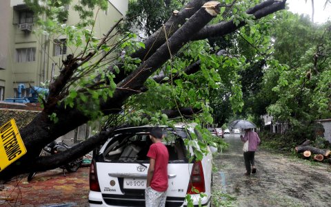 Un niño indio mira el interior de un automóvil averiado en Calcuta, este de la India, el 27 de mayo de 2024.