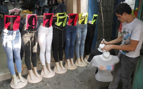 Un vendedor organiza productos en una tienda de ropa.