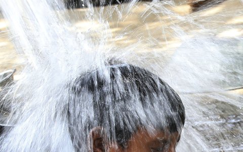Un niño se baña para combatir el calor en Nueva Delhi.