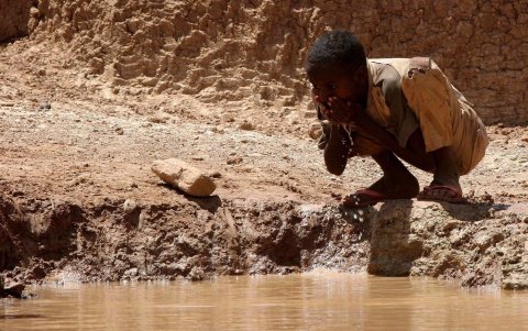 Un niño somalí bebe agua en una presa construida por el hombre en el pueblo de Bur-Dhuxunle al norte de Somalia.