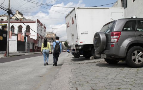 La vereda de la Manuel Larrea y Bogotá está llena de carros que se estacionan en el lugar. Las personas que transitan por la zona deben bajar a la vía.