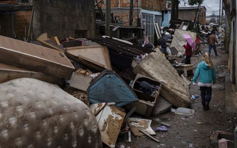 Un niña camina por escombros junto a las casas afectadas por las inundaciones, este lunes en Porto Alegre, Rio Grande do Sul (Brasil).